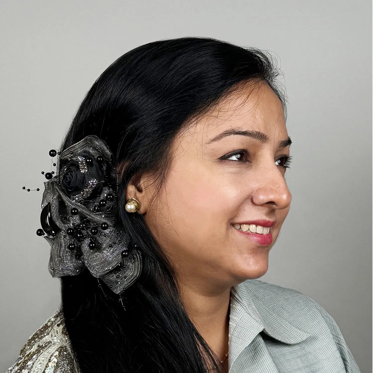 Woman with decorative gray hair claw clutcher against a gray background