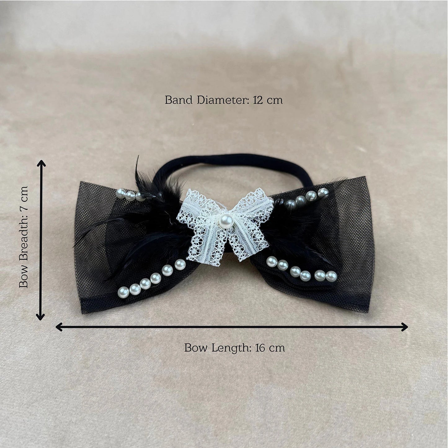 Black bow hair accessory with white lace and pearls, shown with measurements on a beige background.