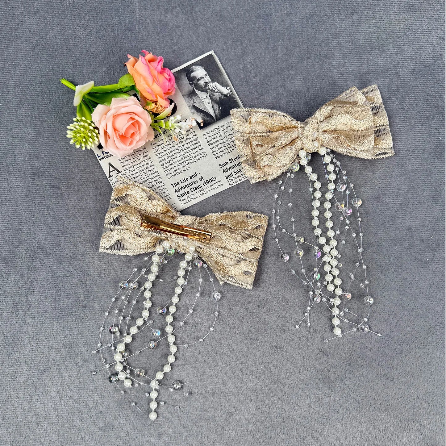 Decorative hair bow with beads and flowers on a gray background