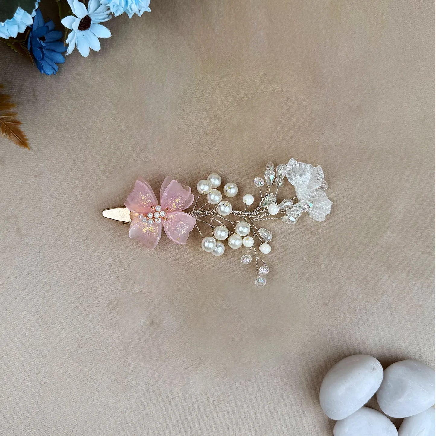 Hair clip with pink flower and pearls on a beige background