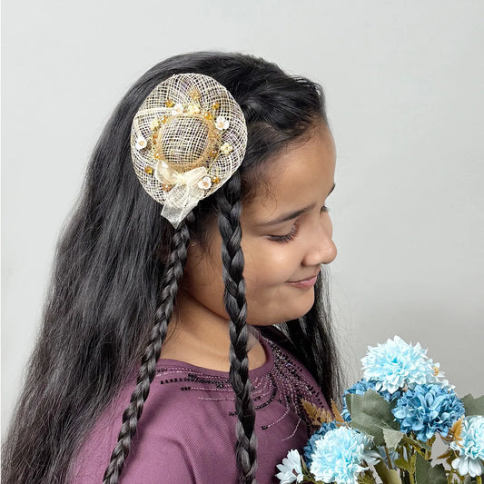 Girl wearing golden fascinator hair clip with floral embellishments