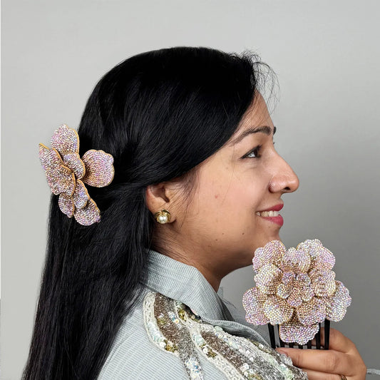 Woman with decorative side hair comb holding another similar comb against a gray background