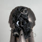 Wig with a decorative black floral hair claw clutcher on a gray background