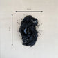 Black floral hair clip with measurements on a light gray background
