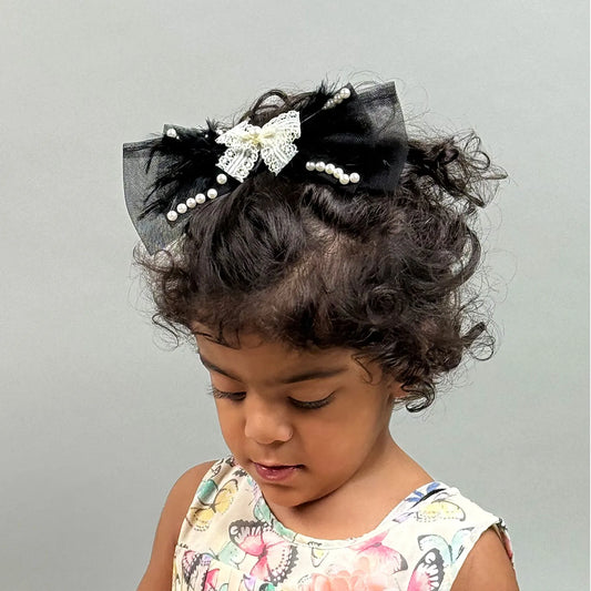 Child with decorative hair bow headband on a plain background