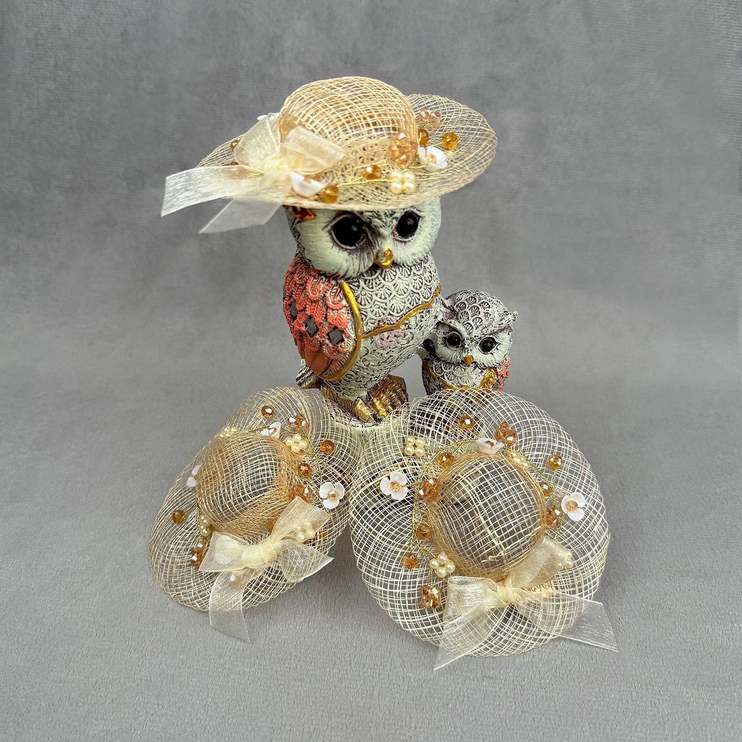 Decorative owl figurine with a fascinator on a gray background