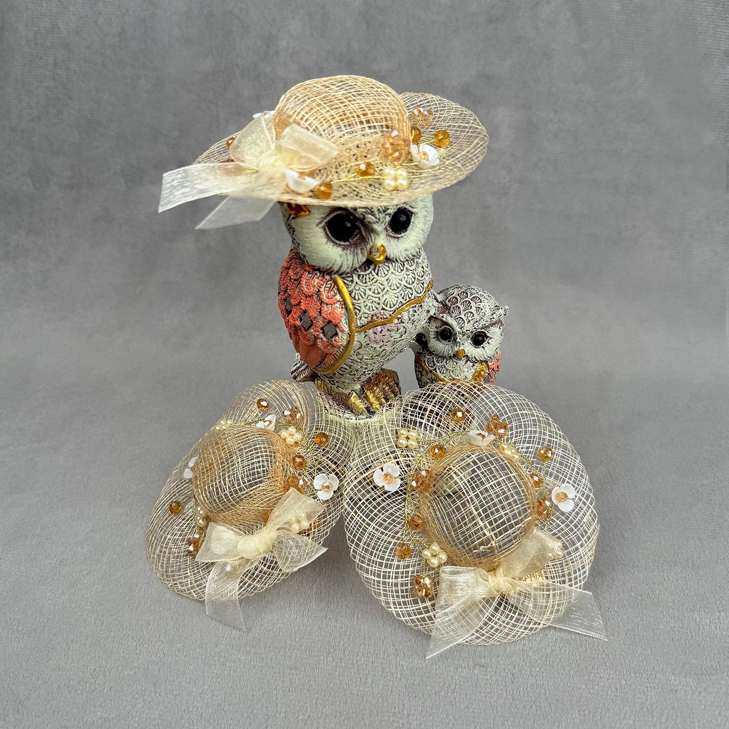 Decorative owl figurine with a fascinator on a gray background