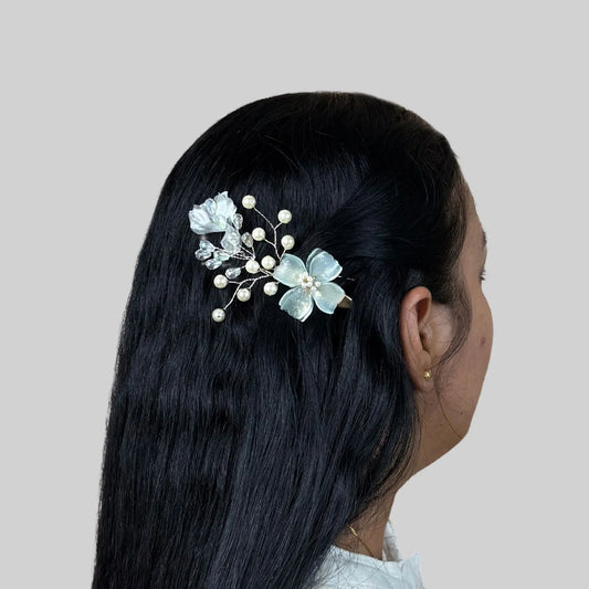 Woman with floral hair accessory on a plain background
