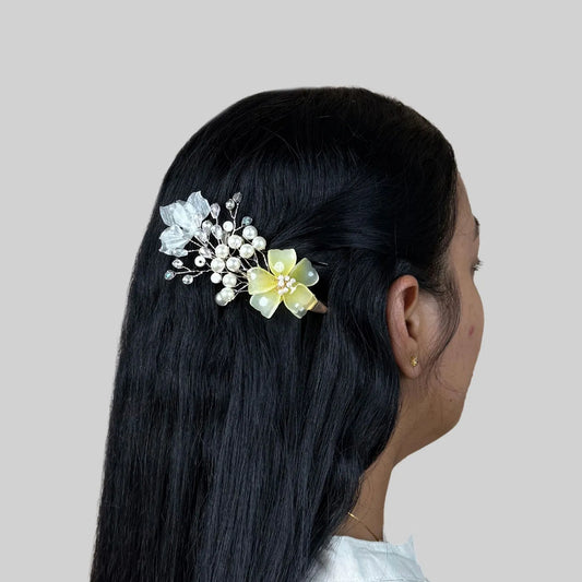 Woman with floral yellow hair accessory on a plain background