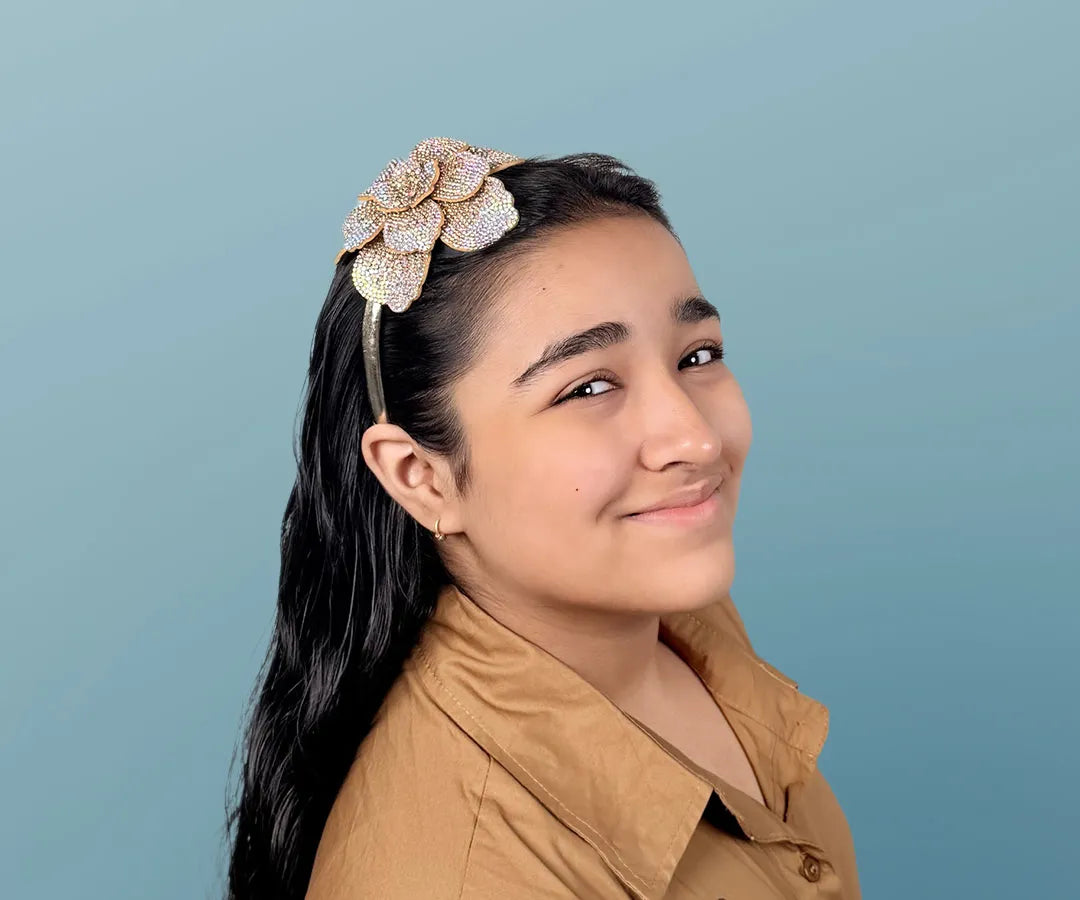 Young girl wearing a decorative headband against a blue background