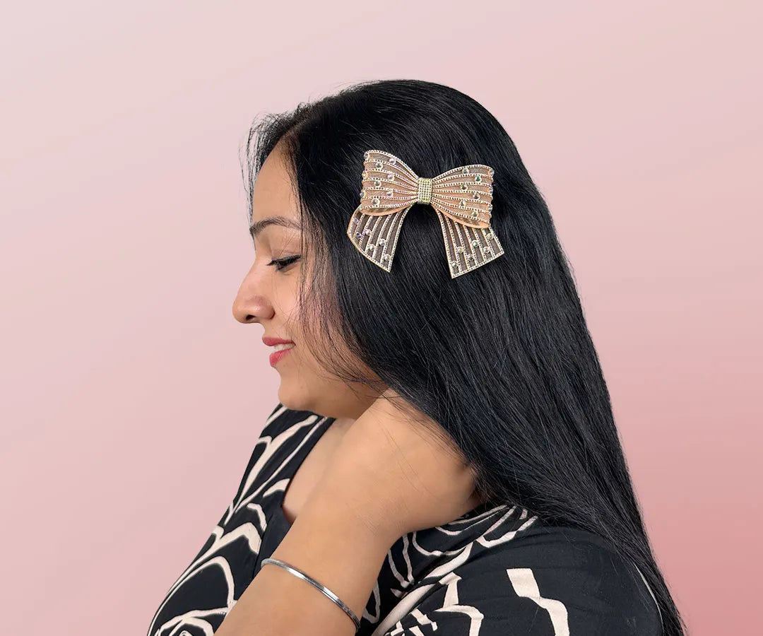 Woman with a decorative hair bow on a pink background